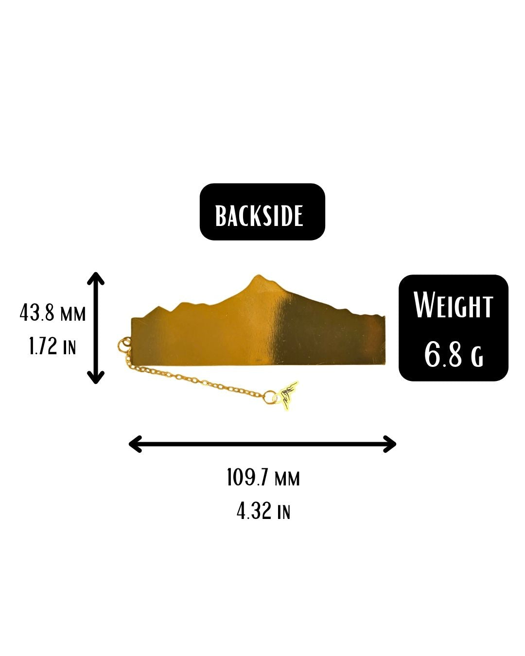 A gold bookmark shaped like a mountain range with a delicate gold chain and a small winged charm attached.