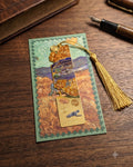 A gold bookmark with a tassel, inspired by Van Gogh's "The Starry Night", rests on a postcard featuring a depiction of the same painting. A vintage book and fountain pen are visible in the background.
