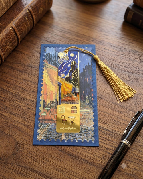 A bookmark featuring Van Gogh's "Cafe Terrace at Night" painting, adorned with a gold tassel and decorative charms.